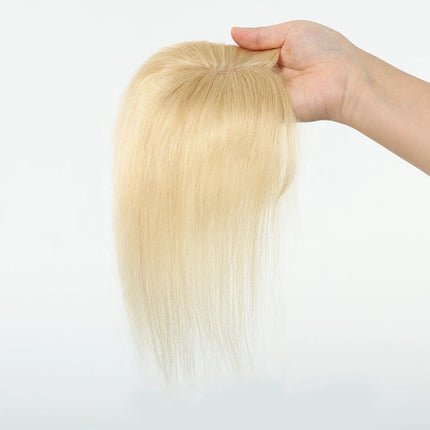 Toupet volumateur blond naturel avec frange droite pour plus de volume et de style.